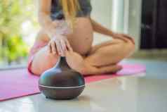 年轻的怀孕了女人瑜伽练习冥想首页香气传播健康护理正念放松健康概念芳香疗法怀孕