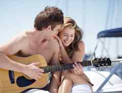 吉他游艇夫妇浪漫的日期感觉快乐兴奋爱海滩海奢侈品音乐男人。唱歌女人成键夏天假期假期