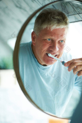 牙科健康需要例程高级男人。刷牙牙齿浴室镜子