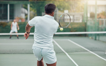 少数民族网球球员持有球拍玩法院游戏后视图未知的团队运动员匹配玩有<strong>竞争力</strong>的双打匹配健身健康体育俱乐部