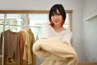 头像年轻的女人显示衣服前面智能手机相机销售衣服在线流媒体