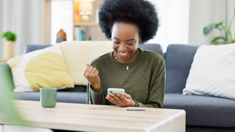 兴奋黑色的女人聊天约会应用程序电话首页年轻的女在线购物快乐购买房子夫人庆祝阅读好社会媒体新闻