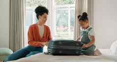旅行行李妈妈包装孩子卧室准备好了旅行帮助手黑色的家庭年轻的女孩妈妈。包衣服手提箱假期假期周末