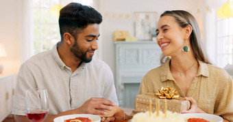 跨种族夫妇礼物庆祝生日快乐吻微笑首页表格蛋糕爱男人。女人内容浪漫的现在快乐的庆祝活动