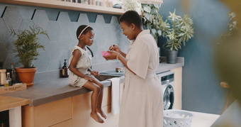 妈妈。孩子早餐妈妈喂养女孩食物营养增长健康健康首页厨房黑色的女人女孩家庭房子质量时间爱吃健康的