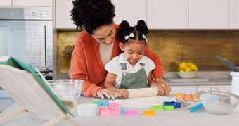 妈妈。女孩学习烘焙厨房滚动花面团计数器烹饪饼干有趣的学习发展快乐妈妈黑色的孩子微笑教学女儿烤