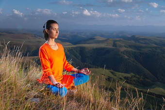 女人实践瑜伽山早....瑜伽实践年轻的女人瑜伽健身练习在户外美丽的山景观