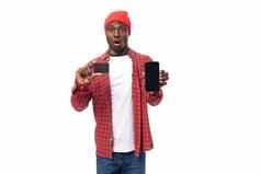 自信年轻的美国男人。红色的头饰衬衫显示手模型卡智能手机购物白色背景复制空间