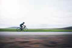 人骑自行车快运动模糊天空模型自行车农村三项全能运动有氧运动培训运动员自行车马拉松比赛速度能源体育锻炼权力行动