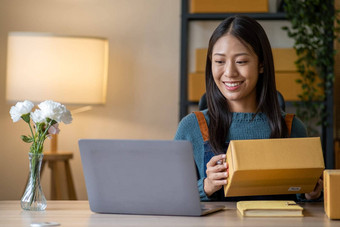 年轻的快乐亚洲女人移动PC屏幕庆祝出售微笑年轻的企业家快乐出售成功的