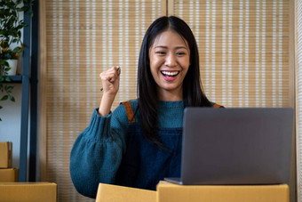 <strong>年轻</strong>的快乐亚洲女人移动PC屏幕庆祝出售微笑<strong>年轻</strong>的<strong>企业家</strong>快乐出售成功的