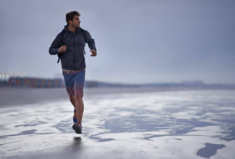 发现灵感健身年轻的男人。慢跑海滩早期早....