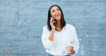 时尚的女记者学生会说话的电话墙复制空间年轻的自信女人享受调用谈话在户外早....杯咖啡