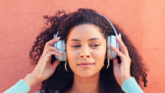 音乐耳机脸快乐黑色的女人听广播首歌声音墙背景非洲女头无线幸福兴奋有趣的音频播放列表在户外