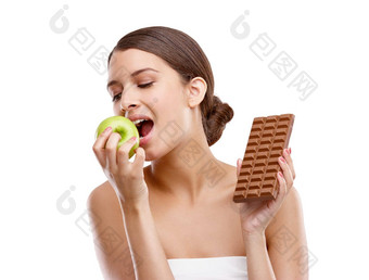 <strong>抵制</strong>诱惑美丽的年轻的女人咬苹果持有巧克力手