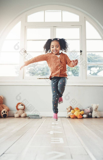 跳房子快乐女孩玩首页有趣的享受游戏放松卧室童年幼儿园兴奋孩子平衡跳游戏玩娱乐活动地板上