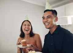 爱夫妇吃蛋糕生日聚会，派对微笑爱的庆祝活动成就快乐的浪漫的男人。女人帽子甜点笑生活房间快乐的