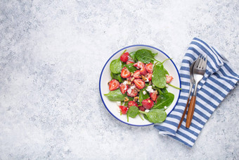 光健康的夏天沙拉新鲜的草莓菠菜奶油奶酪核桃白色陶瓷板白色乡村石头背景前视图空间文本