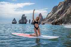女人肉豆蔻海体育女孩冲浪板海阳光明媚的夏天一天黑色的洗澡西装坐在萨帕海休息海