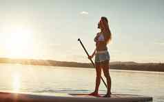 董事会太阳有吸引力的年轻的女人桨登机湖