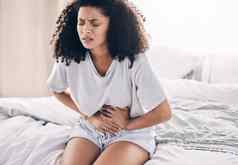 腹部疼痛期黑色的女人床上腹部抽筋月经胃疼痛健康医疗紧急女孩消化问题下午危机子宫内膜异位卧室