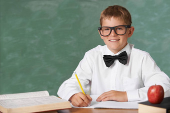 老师梦想年轻的男孩穿眼镜蝴蝶结微笑相机写作书