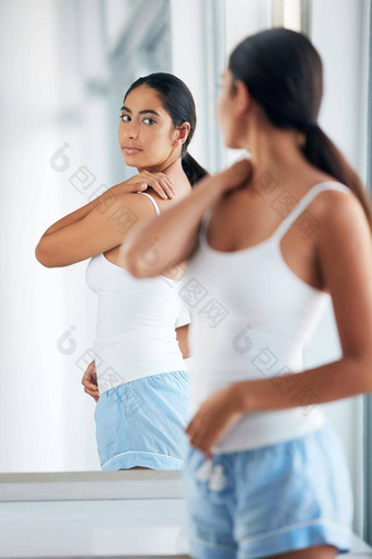 皮肤清晰的有吸引力的年轻的女人<strong>检查</strong>回来前面浴室镜子