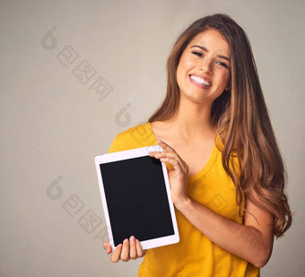 给<strong>设备租赁</strong>生活有吸引力的年轻的女人持有数字平板电脑空白屏幕灰色背景
