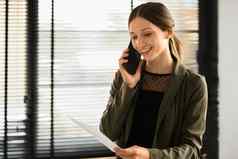 积极的高加索人女金融顾问会说话的移动电话给咨询客户端