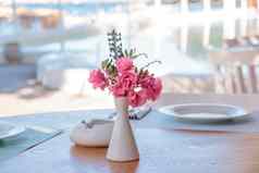 夏天阳台餐厅表铺设白色盘子酒眼镜白色花瓶粉红色的热带花花空户外餐厅表格海边度假胜地夏天