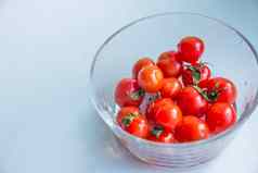 樱桃西红柿透明的碗健康的有机食物蔬菜光蓝色的背景前视图新鲜的有机西红柿