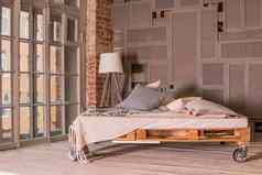 阁楼公寓室内极简主义室内简单的木床上灯大窗口时尚的卧室阁楼风格柔和的颜色复制空间