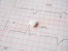白色心形的平板电脑纸心电图结果背景医疗心脏病学的药丸形状心药物恢复健康医疗医疗保健概念