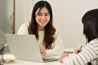 爱的年轻的亚洲妈妈导师老师帮助女儿距离学习在线虚拟类移动PC