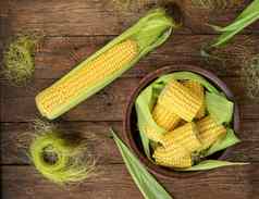结实的矮成熟的生玉米减少耳朵玉米陶瓷菜黑暗木变形表格健康的夏天食物概念新鲜的未煮过的玉米清洁吃习惯背景前视图关闭平躺