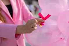 手粉红色的丝带背景粉红色的气球预防周期乳房检查