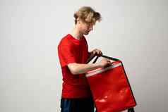 年轻的快递开放热袋白色背景食物交付服务交付的家伙红色的t恤统一的工作快递持有红色的热食物背包服务概念