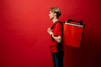 年轻的快递热袋红色的背景空间文本食物交付服务交付的家伙红色的t恤统一的工作快递持有红色的热食物背包服务概念
