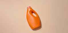 橙色塑料瓶液体洗涤剂洗衣服米色背景前视图