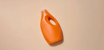 橙色塑料瓶液体<strong>洗</strong>涤剂<strong>洗衣服</strong>米色背景前视图