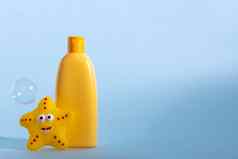 黄色的塑料瓶婴儿化妆品有趣的浴玩具肥皂泡沫背景概念孩子们的浴时间