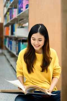 积极的女大学学生坐着书架上阅读书人知识教育概念