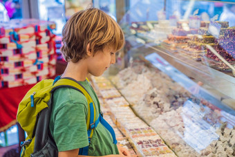 男孩计数器土耳其糖果传统的东方甜蜜的糕点饼干坚果干水果芯块果酱土耳其沙漠糖蜂蜜阿月浑子显示街食物市场