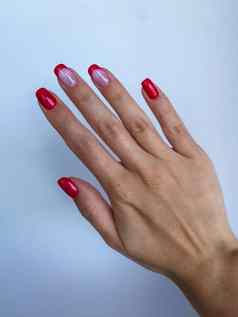 红色的指甲专业修指甲女人手米色袖