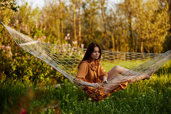 女人坐着网吊床自然放松享受射线<strong>设置</strong>太阳相机温暖的夏天一天水平照片<strong>主题</strong>户外娱乐