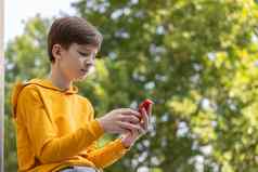 streetstyle照片年轻的男孩智能手机沟通玩游戏游戏学校