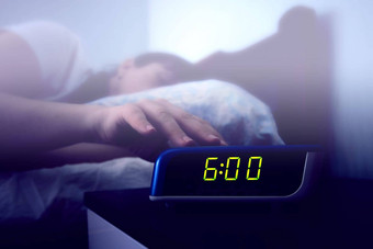 睡觉女人的手到达数字报警时钟床边表格颜色爽肤水阴霾过滤器图像