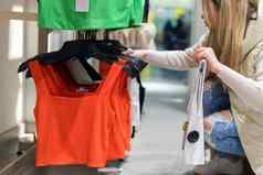 快乐年轻的女人购买衣服商店出售购物时尚人概念