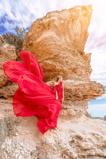 女人红色的<strong>丝绸衣服</strong>站海洋山背景<strong>衣服</strong>摇摆微风