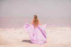 女人粉红色的盐湖背景粉红色的盐湖女人长粉红色的衣服需要悠闲的漫步白色咸海岸捕捉旅游热时刻
